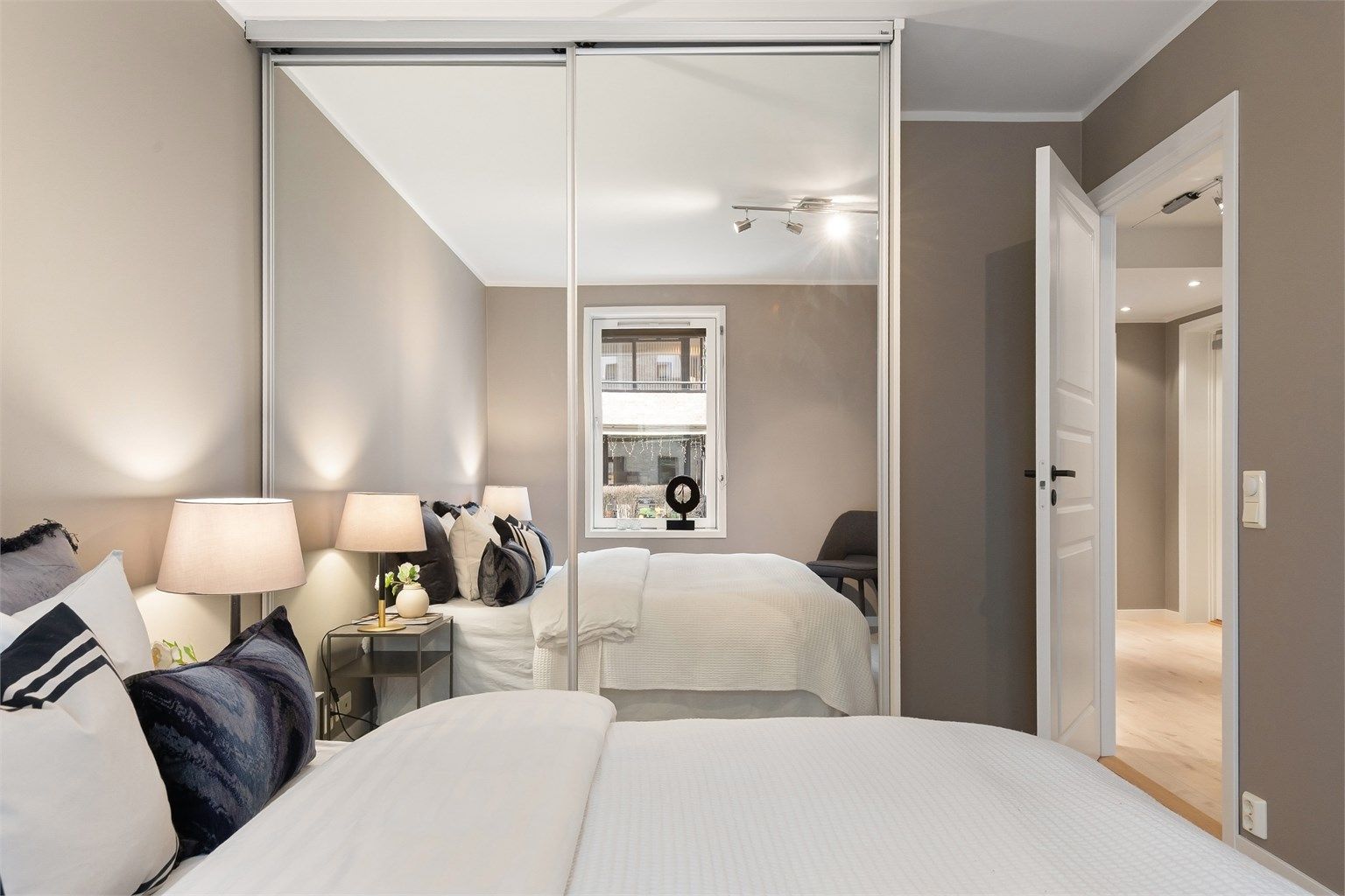 En stor skyvedørsgarderobe med speilfronter gir rikelig med oppbevaringsplass.