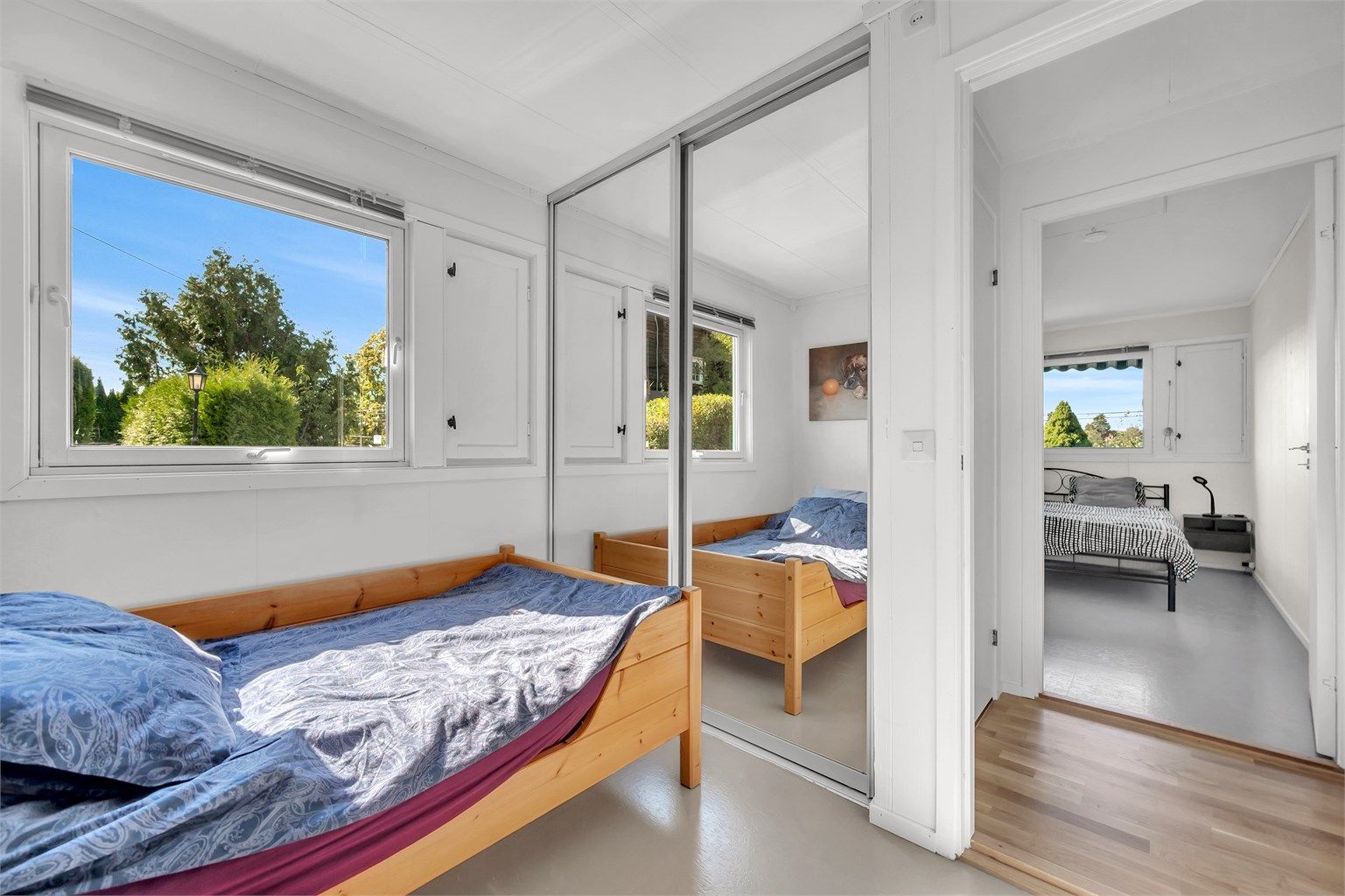 Rommet har en praktisk skyvedørsgarderobe med speilfronter. 