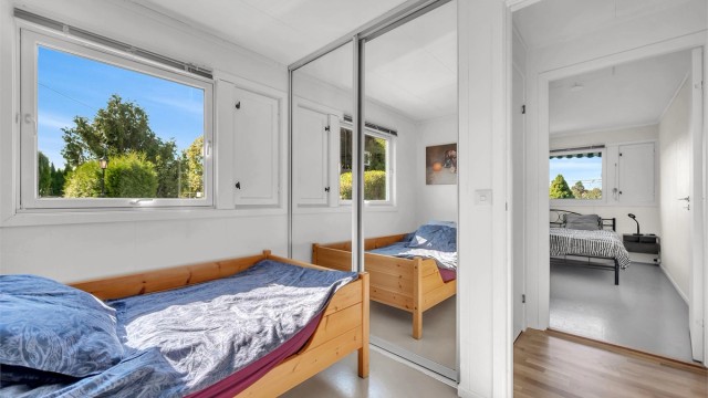 Rommet har en praktisk skyvedørsgarderobe med speilfronter.