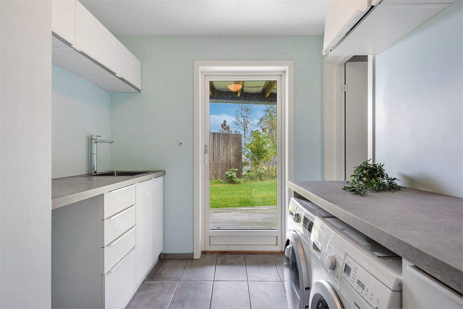 Praktisk vaskerom med egen utgang, gode arbeidsflater og opplegg for vaskemaskin og tørketrommel.