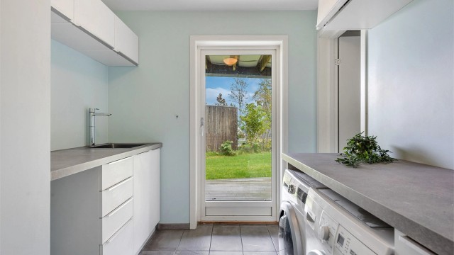 Praktisk vaskerom med egen utgang, gode arbeidsflater og opplegg for vaskemaskin og tørketrommel.