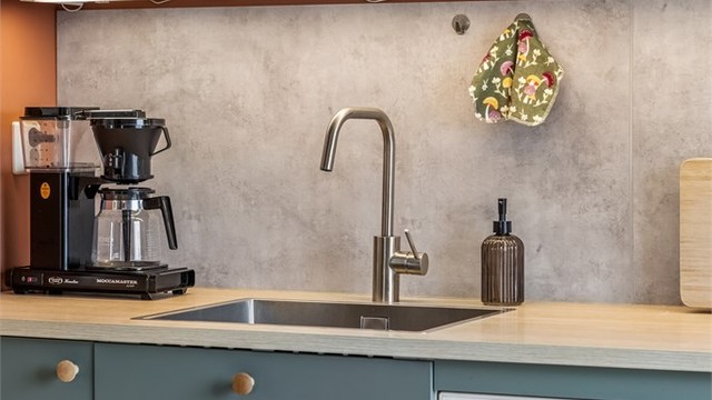 Det er montert laminert plate over kjøkkenbenk, samt belysning og stikkontakter under overskap.