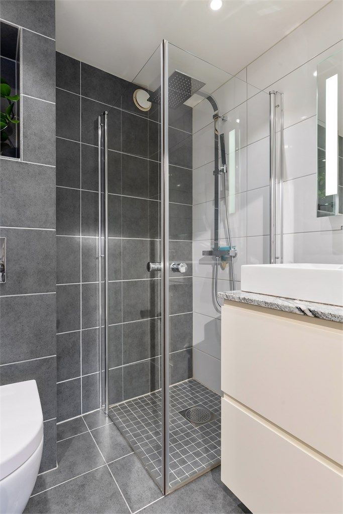 Dusjsonen har innfellbare glassdører og et dusjarmatur med både hånddusj og regndusj.