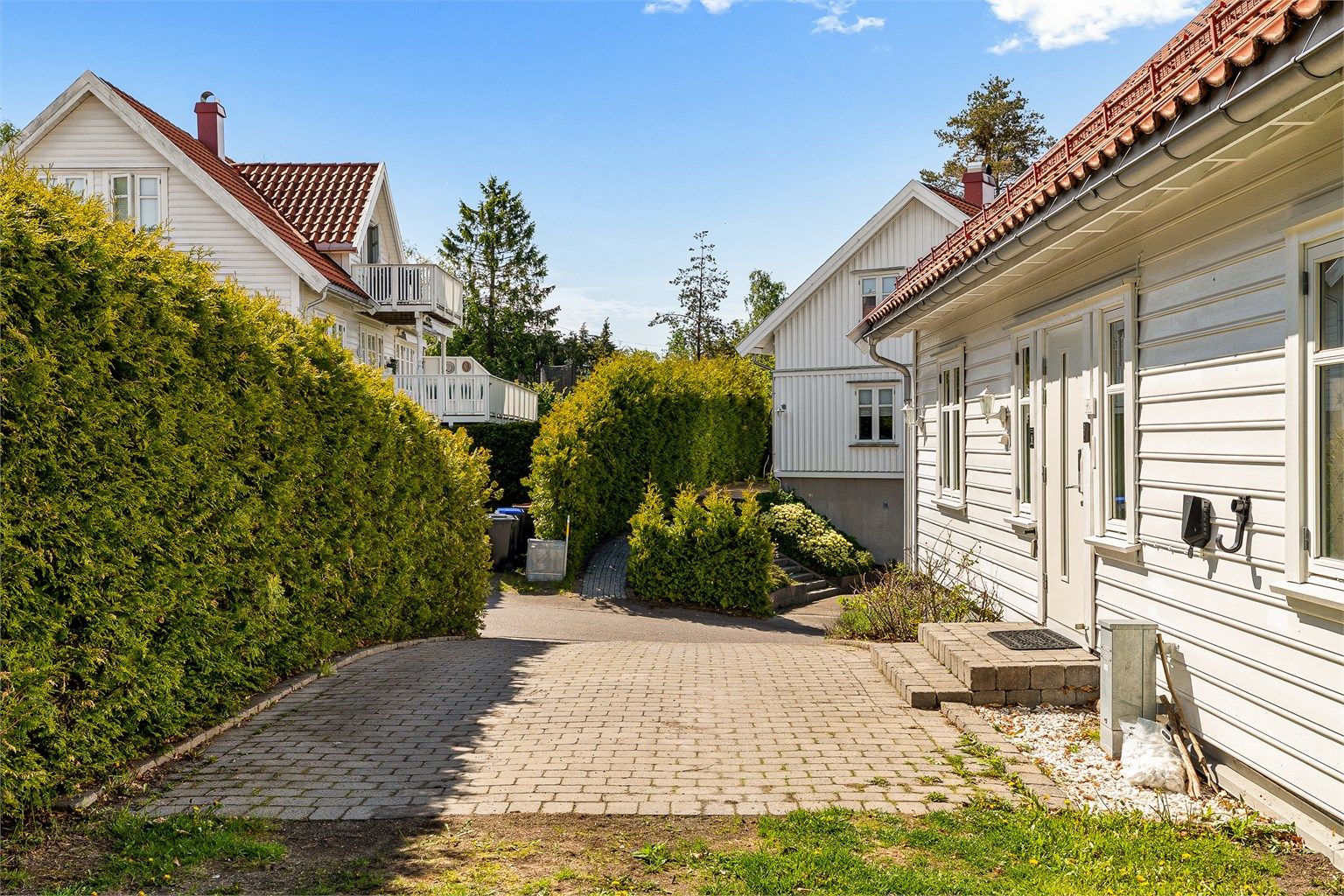 Gårdsplass med belegningsstein fører frem til inngangspartiet.
