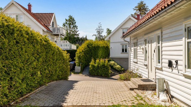 Gårdsplass med belegningsstein fører frem til inngangspartiet.