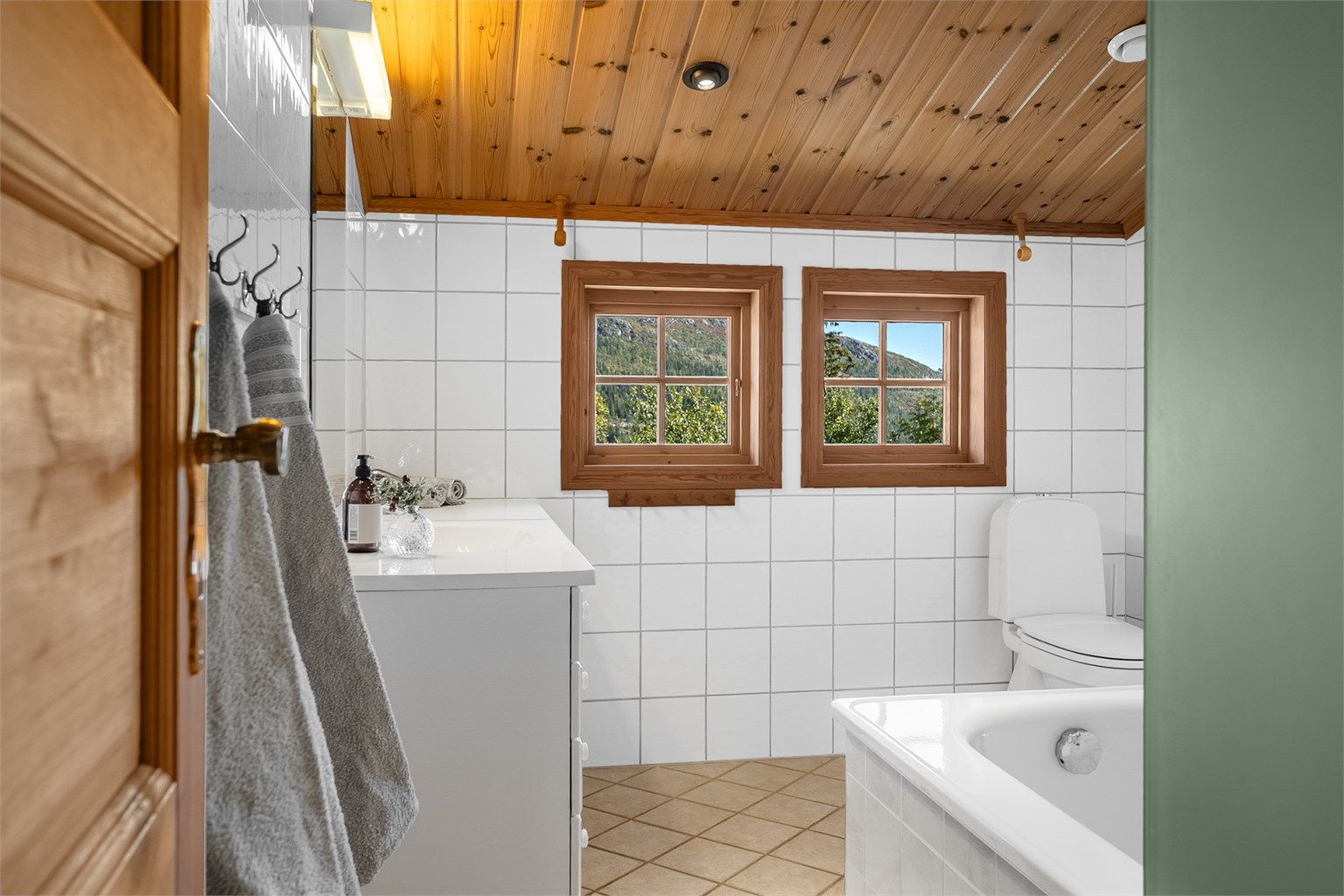 Badet er innredet med fliser på vegger og oppvarmet flisgulv.