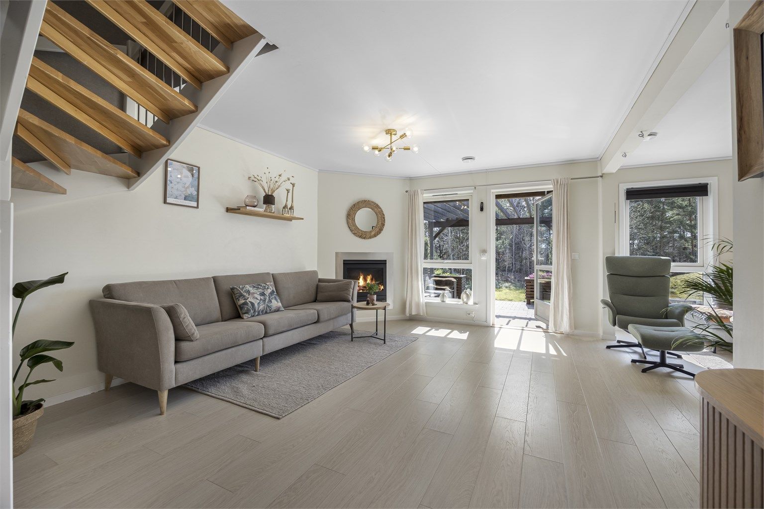 Romslig stue i første etasje med åpen forbindelse til kjøkkenet.