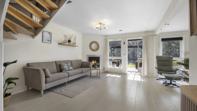 Romslig stue i første etasje med åpen forbindelse til kjøkkenet.