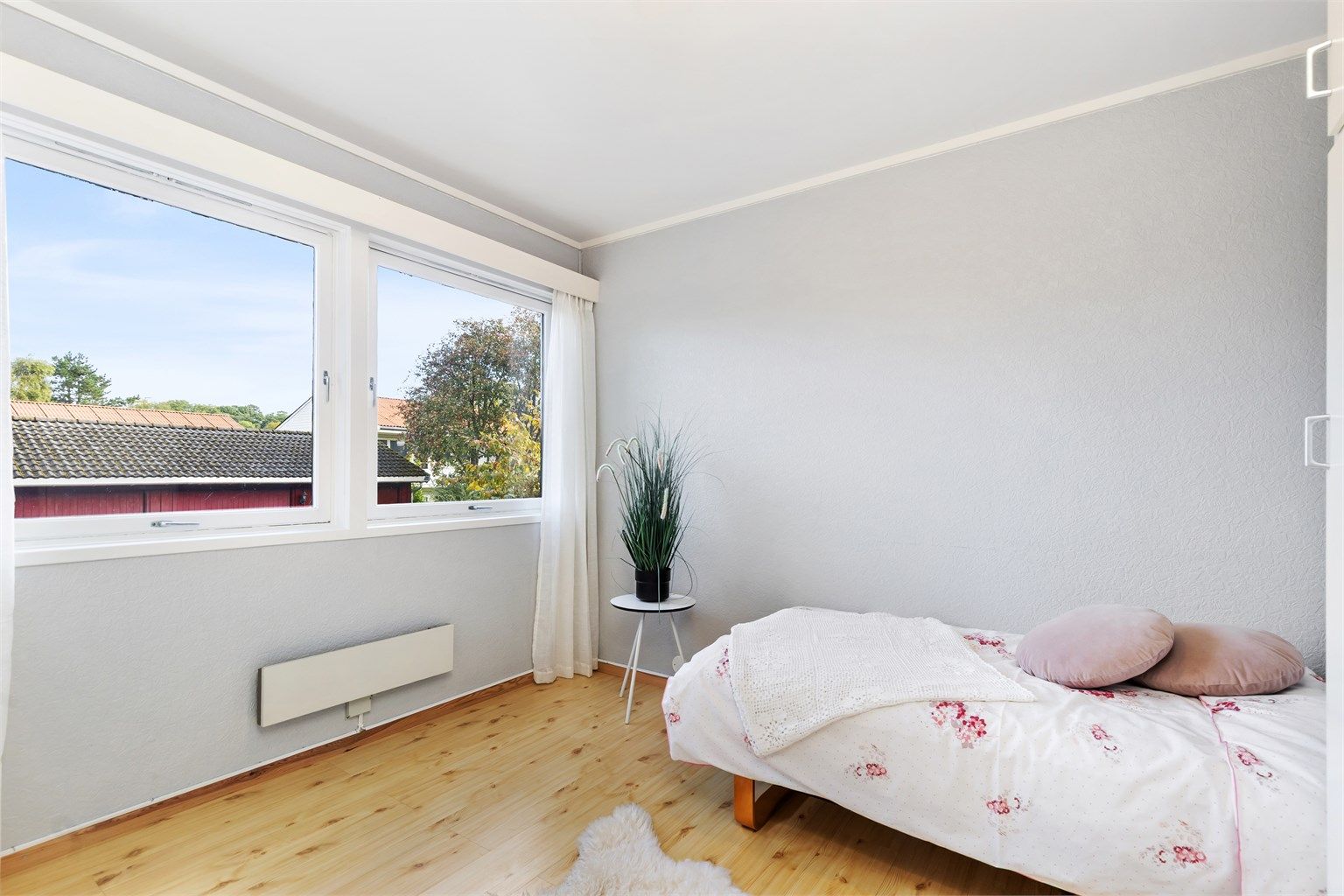Gode vindusflater gir rikelig med naturlig dagslys til soverommet.