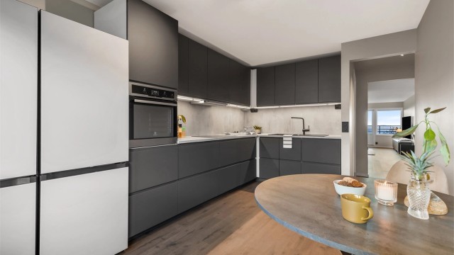 Kjøkken med innredning fra 2023. Glatte fronter. Benkeplate med laminert overflate. Kjøkkenvask med armatur. Integrert stekeovn, platetopp og oppvaskmaskin.