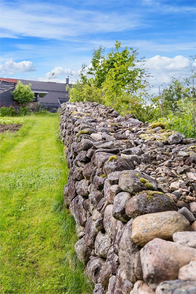 Langs eiendommens grense er det bygget en flott steingjerde i naturstein som er stablet