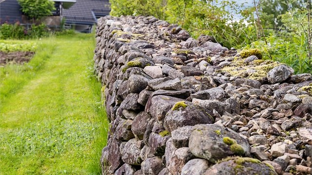 Langs eiendommens grense er det bygget en flott steingjerde i naturstein som er stablet