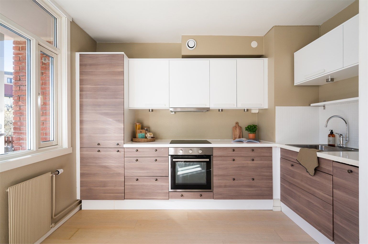 Kjøkkenet har rikelig med skap- og benkeplass. Innredningen fra Ikea har skapdører i glatte fronter og laminat benkeplate.