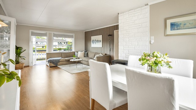 Frittstående peisovn med plate på gulv, pent plassert i midten av rommet.