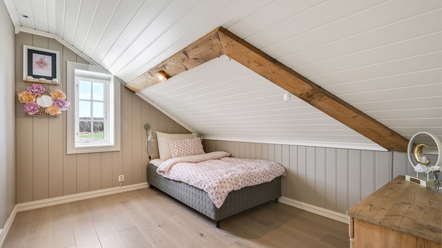 Det tredje soverommet i etasjen har synlige takbjelker som gir en sjarmerende detalj.