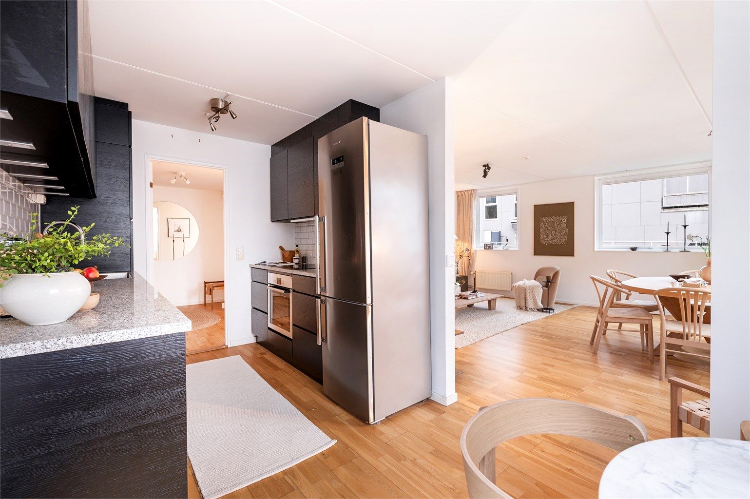 En delvis åpen stue-/kjøkkenløsning skaper en sosial bolig, perfekt for sammenkomster. 