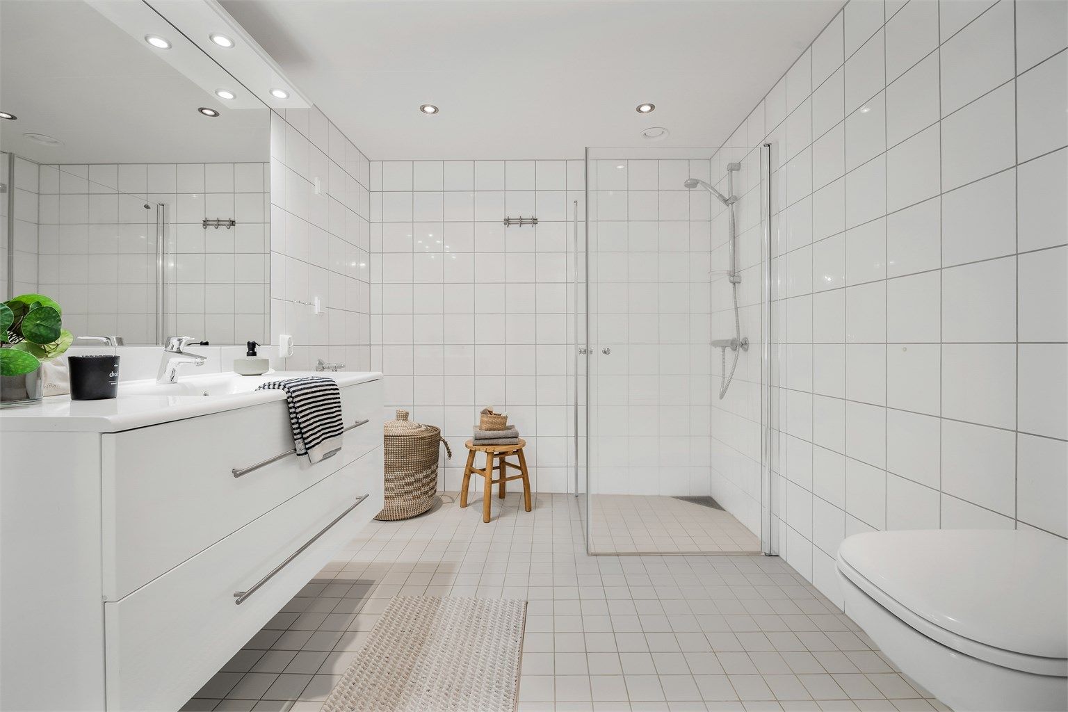 Lyst flislagt bad med downlights i tak og gulvvarme.
