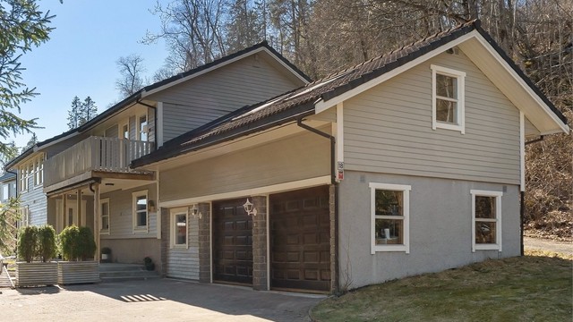 Eiendommen har en stor, steinlagt gårdsplass og en tilliggende dobbelgarasje med elektriske leddporter, som gir rikelig med parkerings- og lagringsplass.