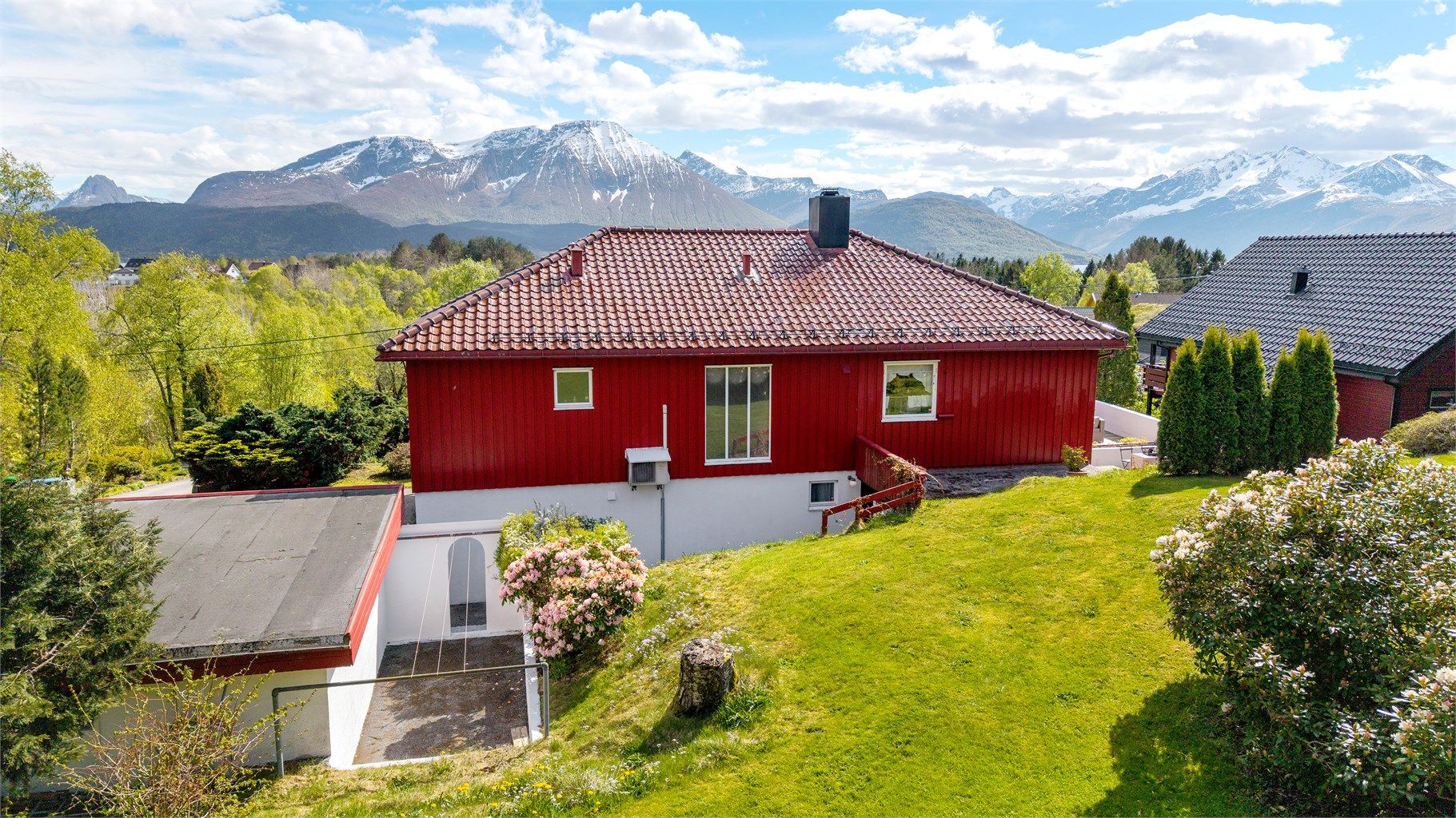 Baksiden av boligen med utgang fra underetasjen. Her ligger også en utebod som er tilbygd mot nord.