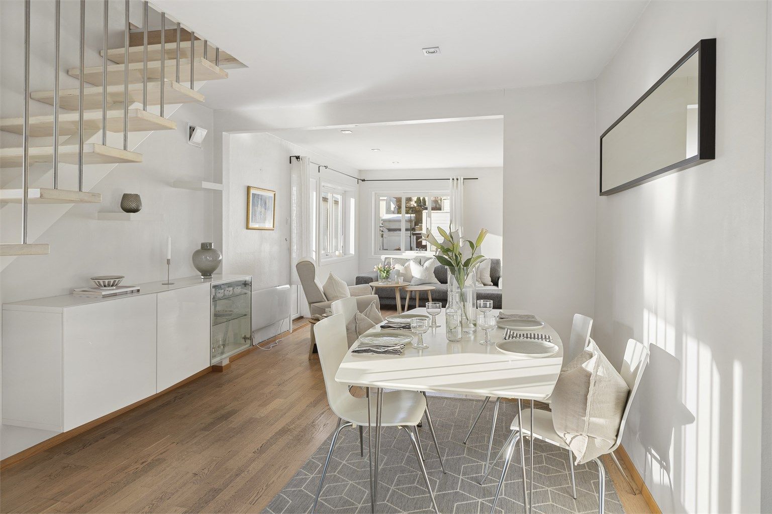 Leiligheten har en lys og luftig stue i åpen løsning med spisestue og kjøkken.