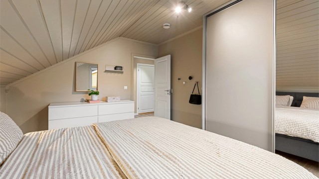 Soverommet har laminatgulv og malte panelbord i himlingen.