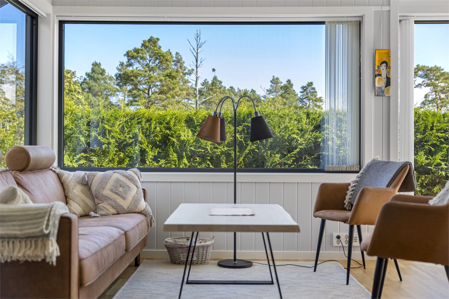 Stuedelen har plass til en komfortabel sofagruppe, med utsikt mot de grønne omgivelsene.