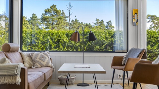 Stuedelen har plass til en komfortabel sofagruppe, med utsikt mot de grønne omgivelsene.