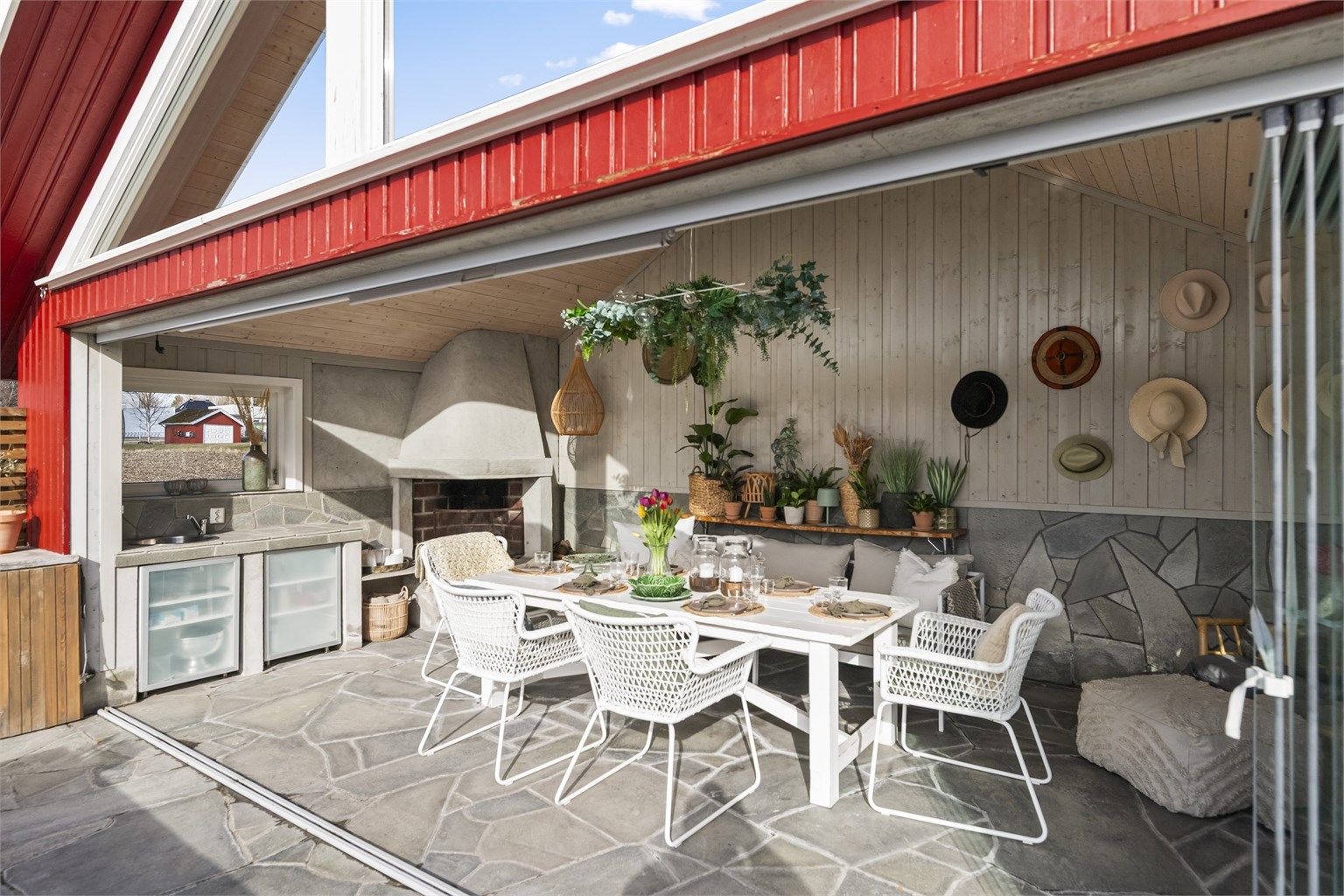 Her er det plassbygget utekjøkken og en stor, åpen peis som skaper stemning på kjølige kvelder.