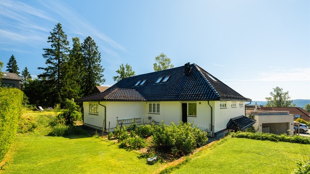 Fra det ene soverommet i hovedetasjen er det utgang til hagen på baksiden av huset.