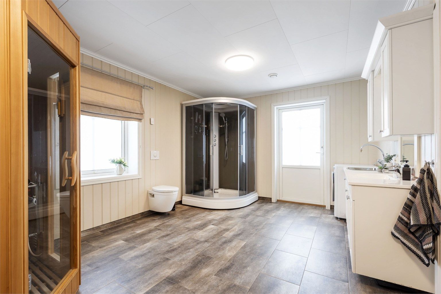 Særdeles romslig bad/vaskerom med dusjkabinett (nytt), wc, badstue og innredning med servant og utslagsvask
