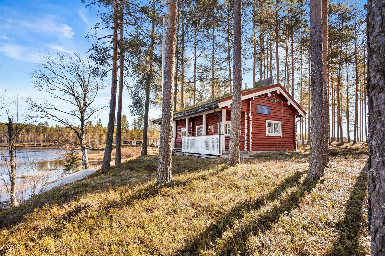 Fritidsbolig i laft med torvtak, usjenert plassert på en naturtomt ved vannet.
Foto: [Fotograf eller fotofirma]