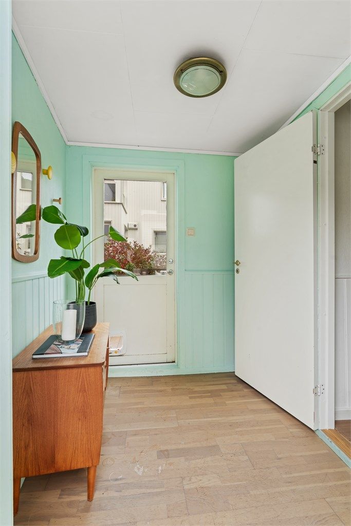 Entreen har malt panel på veggene og plass til oppbevaringsmøbler.
