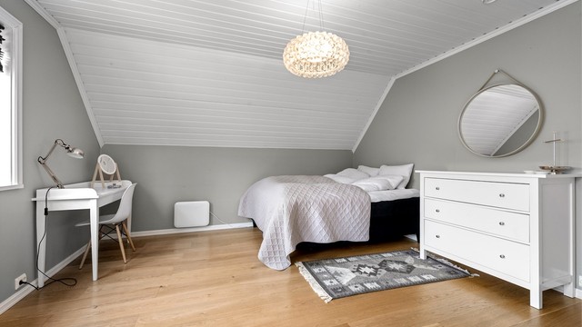 Soverom med god plass til seng og nattbord, samt en liten arbeidsplass.