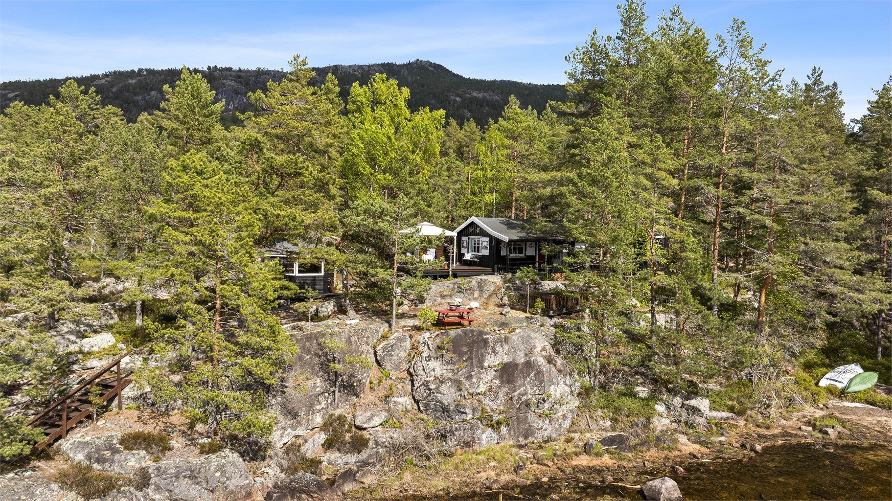 Denne fritidsboligen ligger usjenert til på en egen odde ved Nisser, omgitt av en kupert naturtomt.
Foto: Fotograf Magik