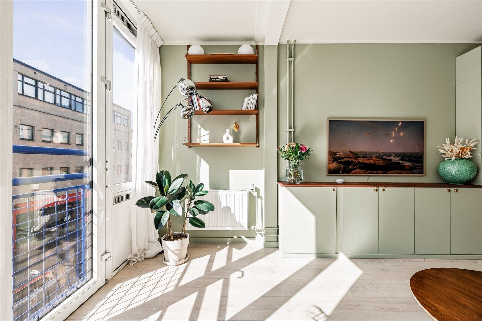 Leiligheten har god takhøyde og store vindusflater vegg til vegg som slipper inn rikelig med lys og skaper en luftig atmosfære.
