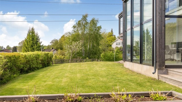 Den store tomten på ca. 1,5 mål er pent opparbeidet med plenarealer og beplantning.