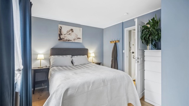 Rommet har god plass til en stor dobbeltseng med tilhørende nattbord.