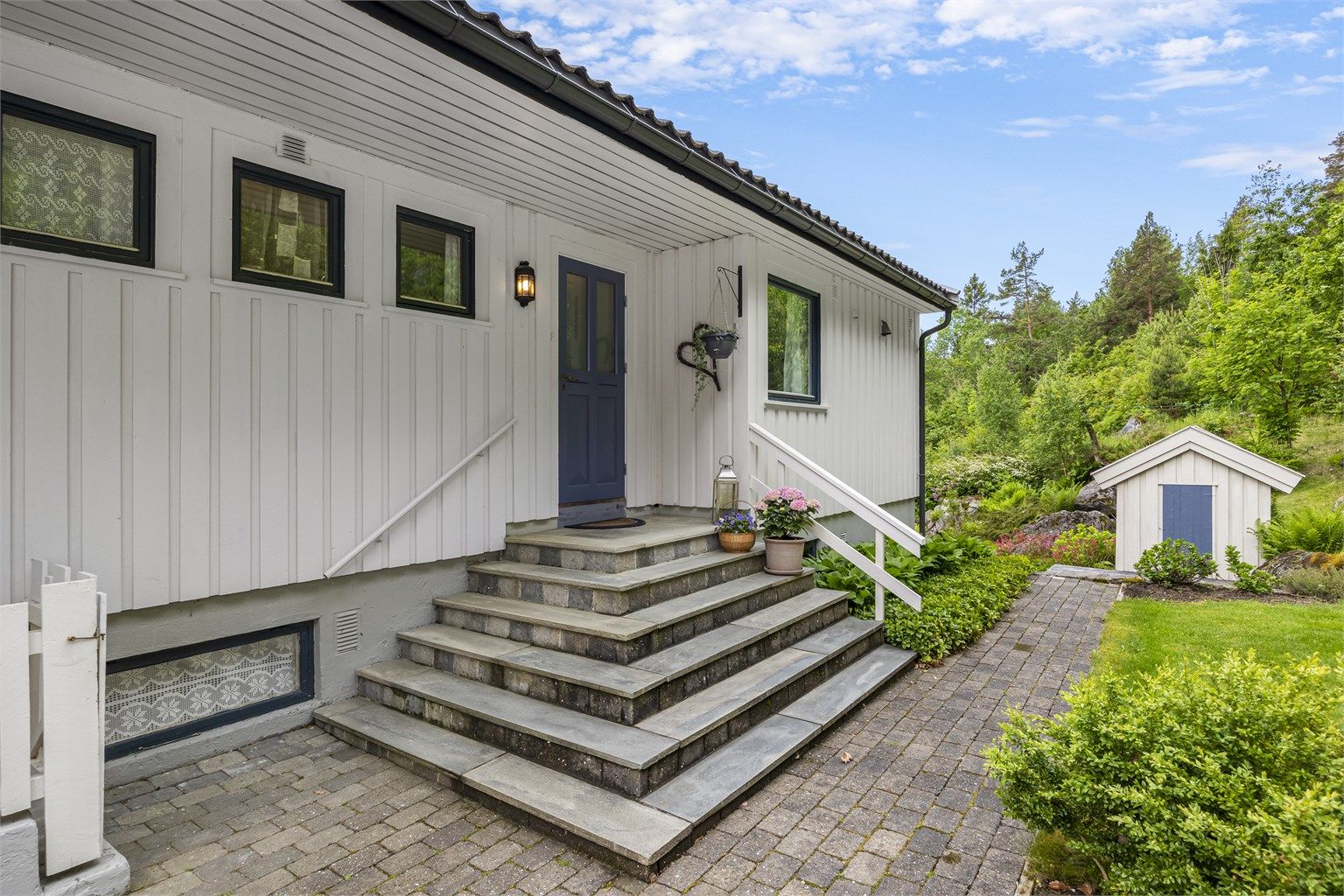 Inngangspartiet har en solid trapp og er delvis overbygd.