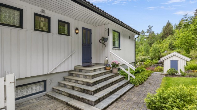 Inngangspartiet har en solid trapp og er delvis overbygd.