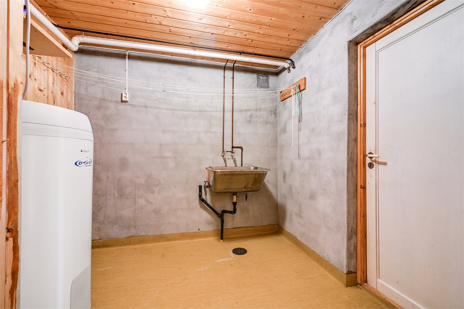Separat vaskerom med opplegg for vaskemaskin. Her er også boligens varmtvannsbereder fra 2009 plassert.