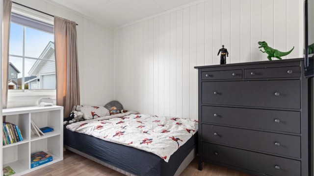 Boligen har et praktisk soverom i første etasje, med parkett på gulvet.