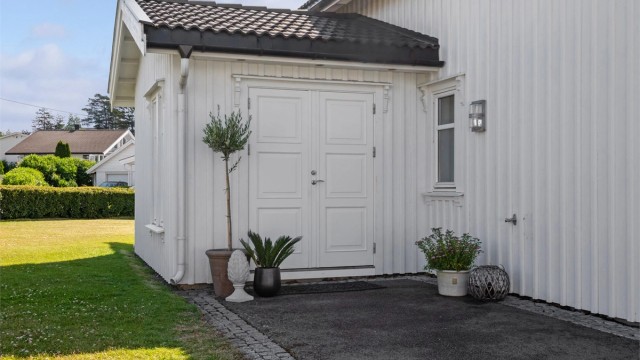 Ytterdøren er tofløyet og overbygd, og ved inngangen har boligen vannkran, downlights og plass til et koselig kafésett.