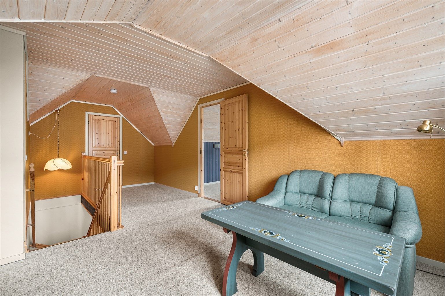 Loftstuen fremstår som et lunt og hyggelig oppholdsrom med skråhimling som gir særpreg og en ekstra koselig atmosfære.