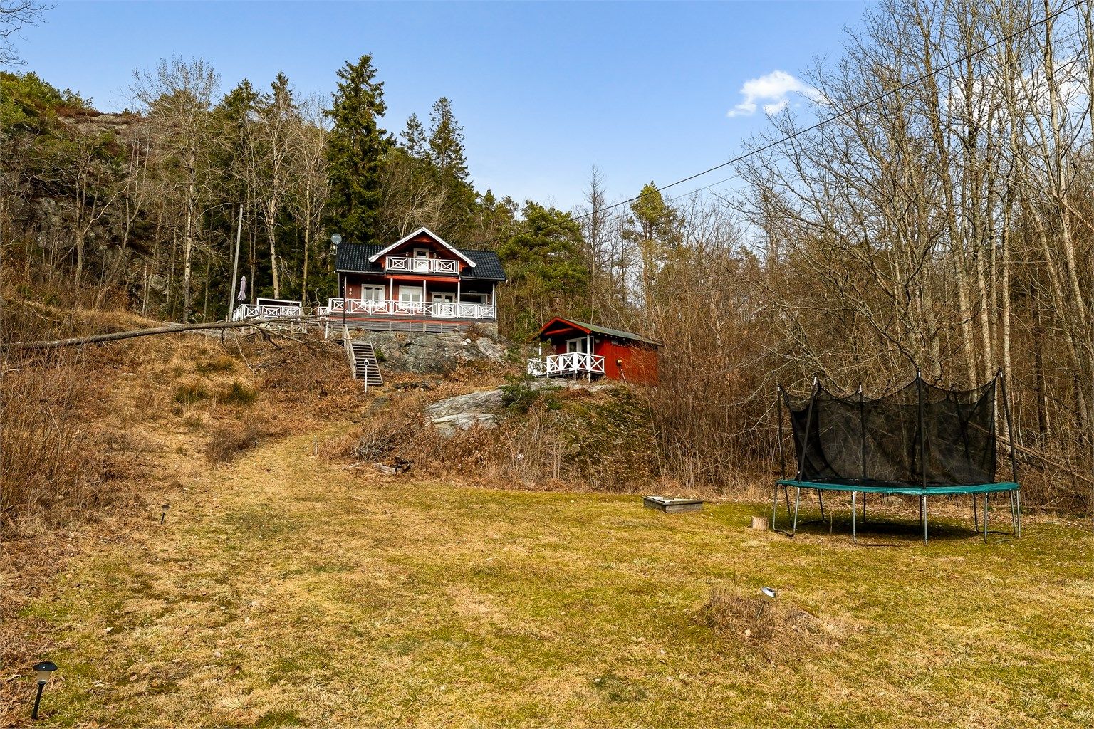 Området med gresslette nedenfor hytte ligger på utsiden av tomten, men har vært benyttet av hytteeier til trampoline, lek og ballspill.