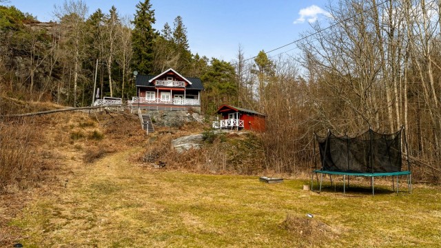 Området med gresslette nedenfor hytte ligger på utsiden av tomten, men har vært benyttet av hytteeier til trampoline, lek og ballspill.