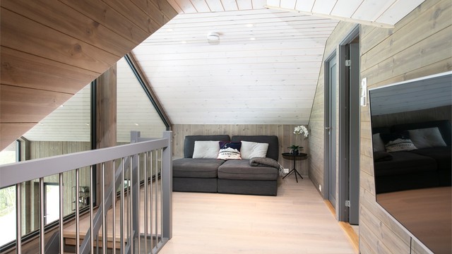 Koselig loftstue med skråhimling, innfelte spotter og god plass til sittegruppe og TV.