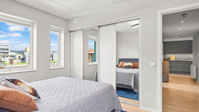En stor skyvedørsgarderobe med speilfronter gir rikelig med oppbevaringsplass.