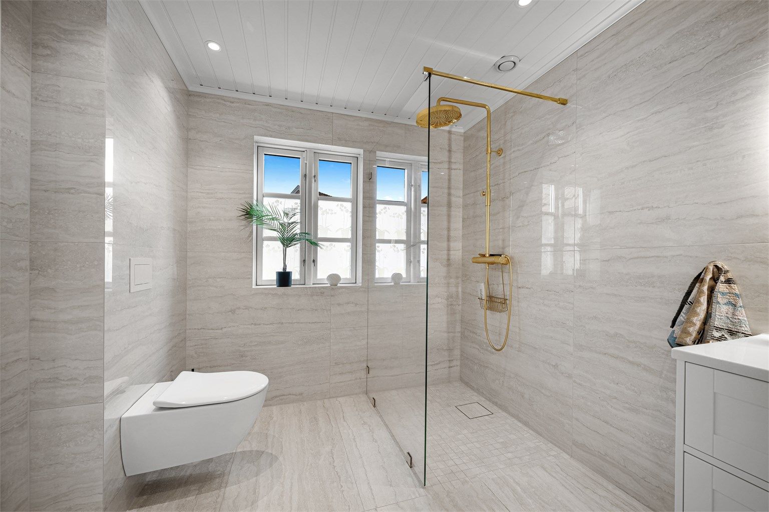 WC med innebygget cisterne og dusjarmatur i messing.