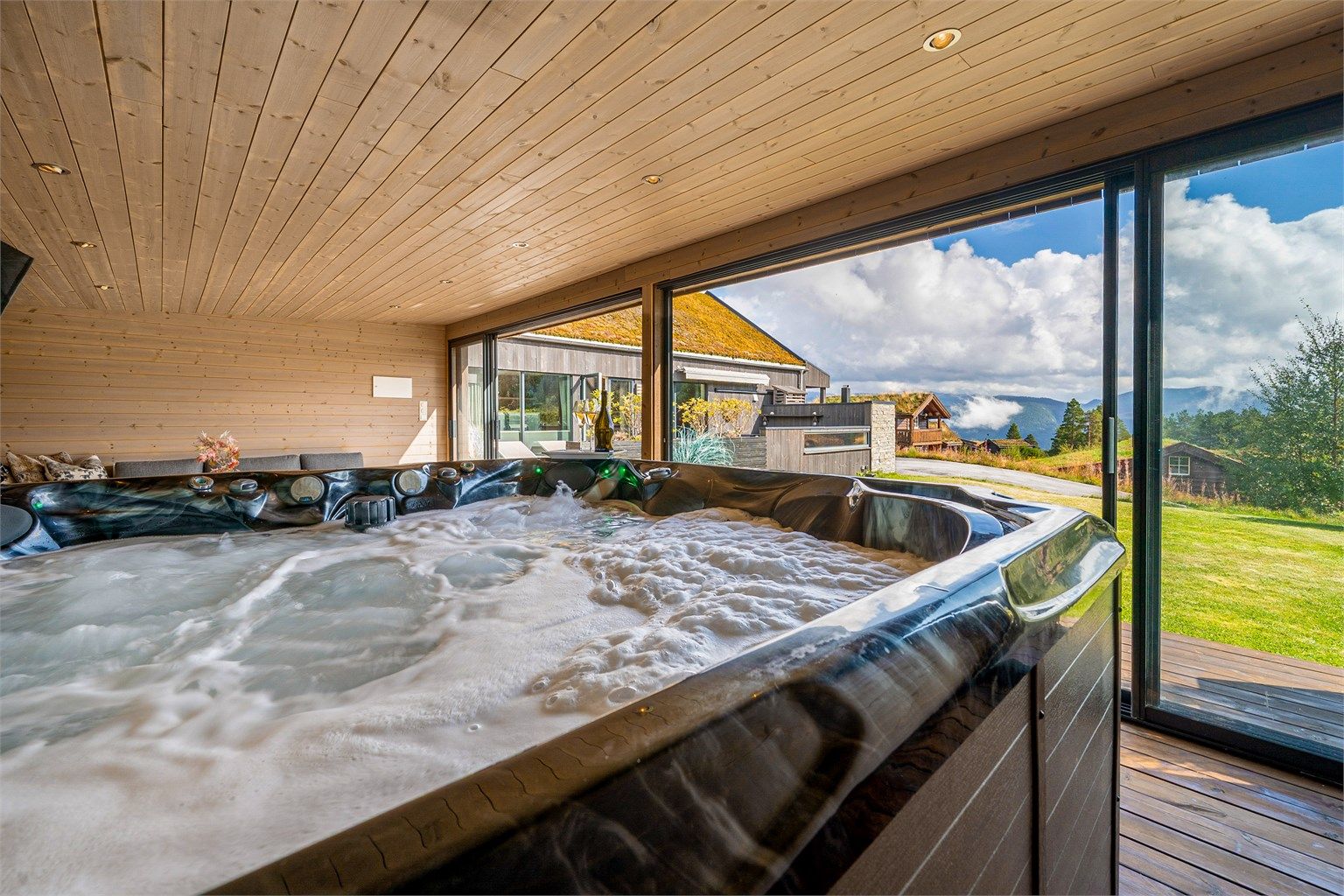Stor og sosial hagestue med boblebad og skyvedører ut til hage og uteområdet med fantastisk utsikt 