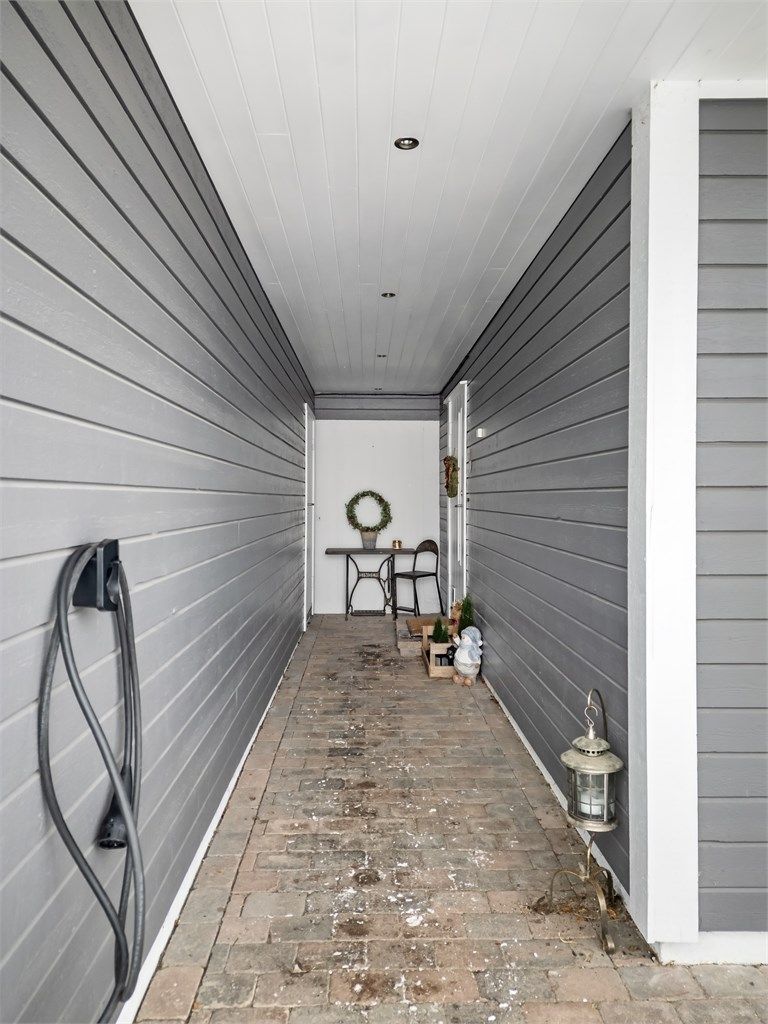 Overbygget inngangsparti i underetasjen med adkomst til boligen og en utvendig bod.